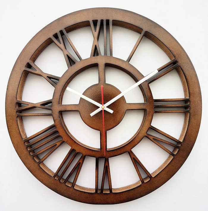 A brown MDF wall clock with Roman numerals.
