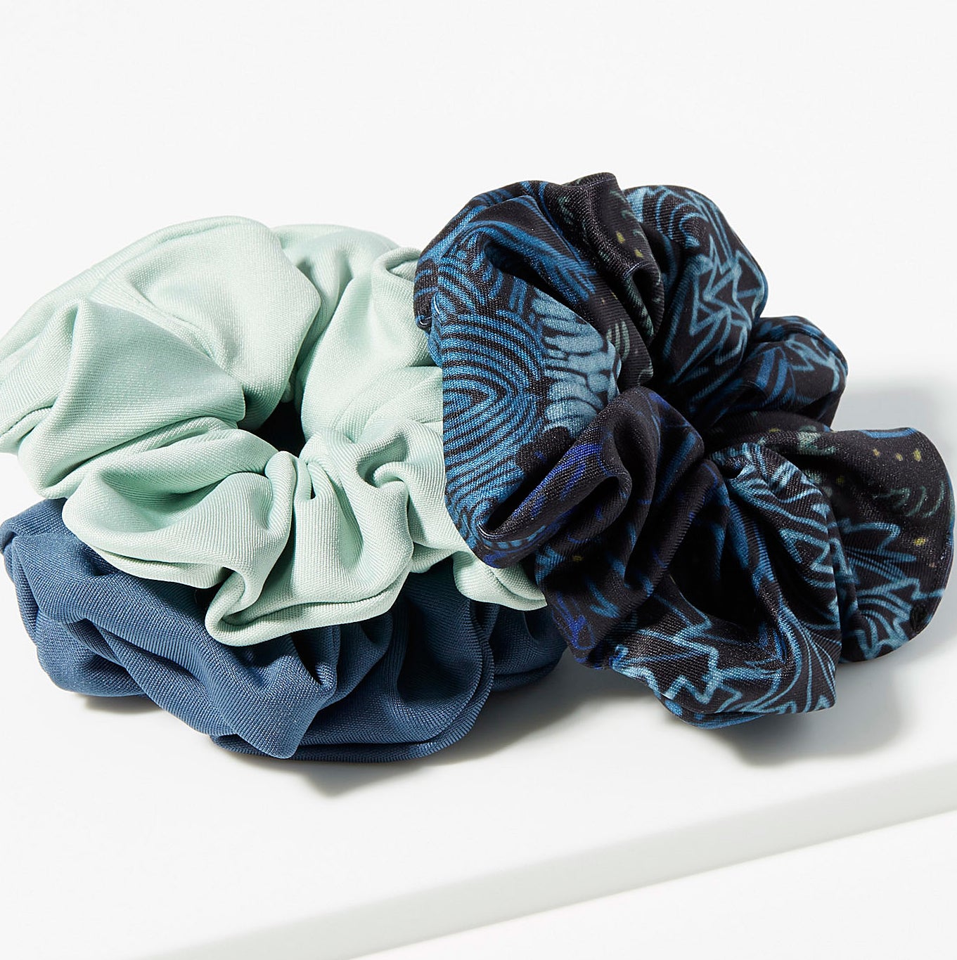 The three scrunchies in a pile on a table