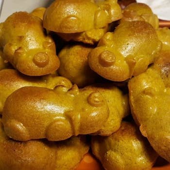 A reviewer's perfect golden brown pig-shaped pigs in a blanket, complete with heads, bodies, noses, ears, and legs