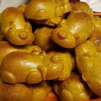 A reviewer's perfect golden brown pig-shaped pigs in a blanket, complete with heads, bodies, noses, ears, and legs