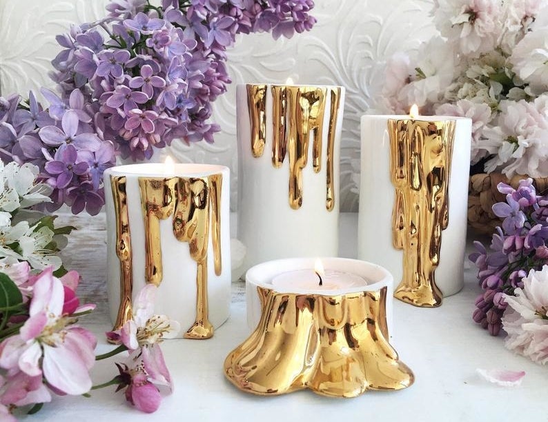 The white and gold candle holders in various sizes — they&#x27;re white with a gold wax-dripping design
