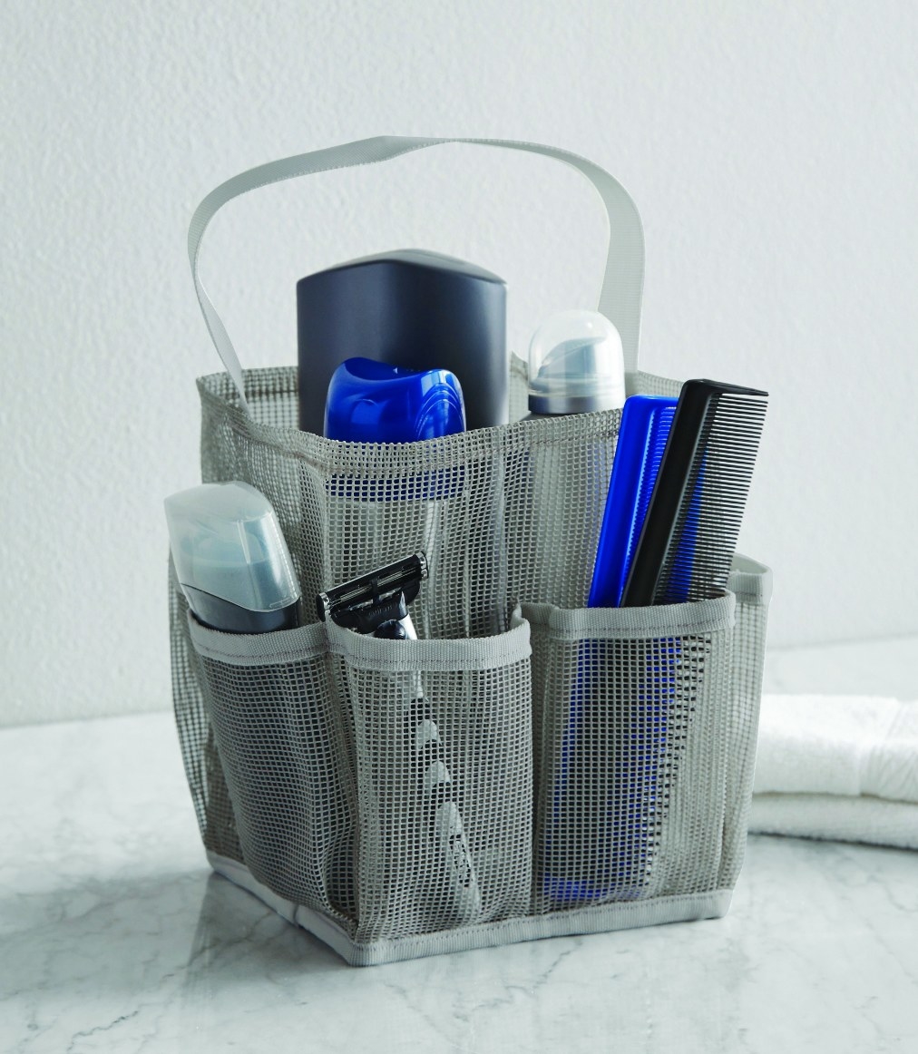 The shower tote being used to hold a razor, deodorant, and combs