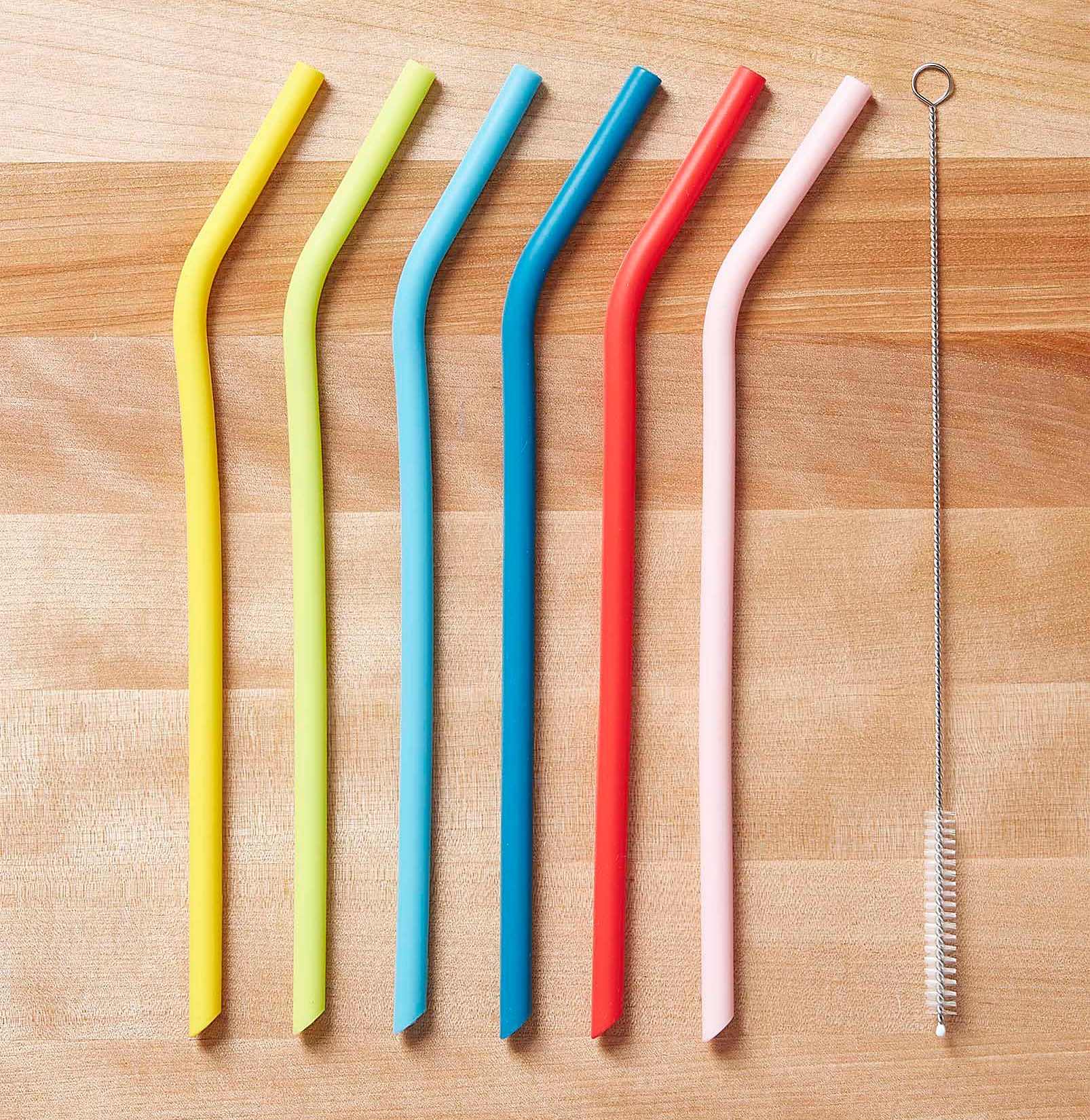 The six straws and their cleaning brush on a table