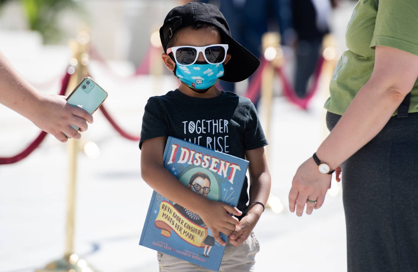 A boy carries a book that says I dissent