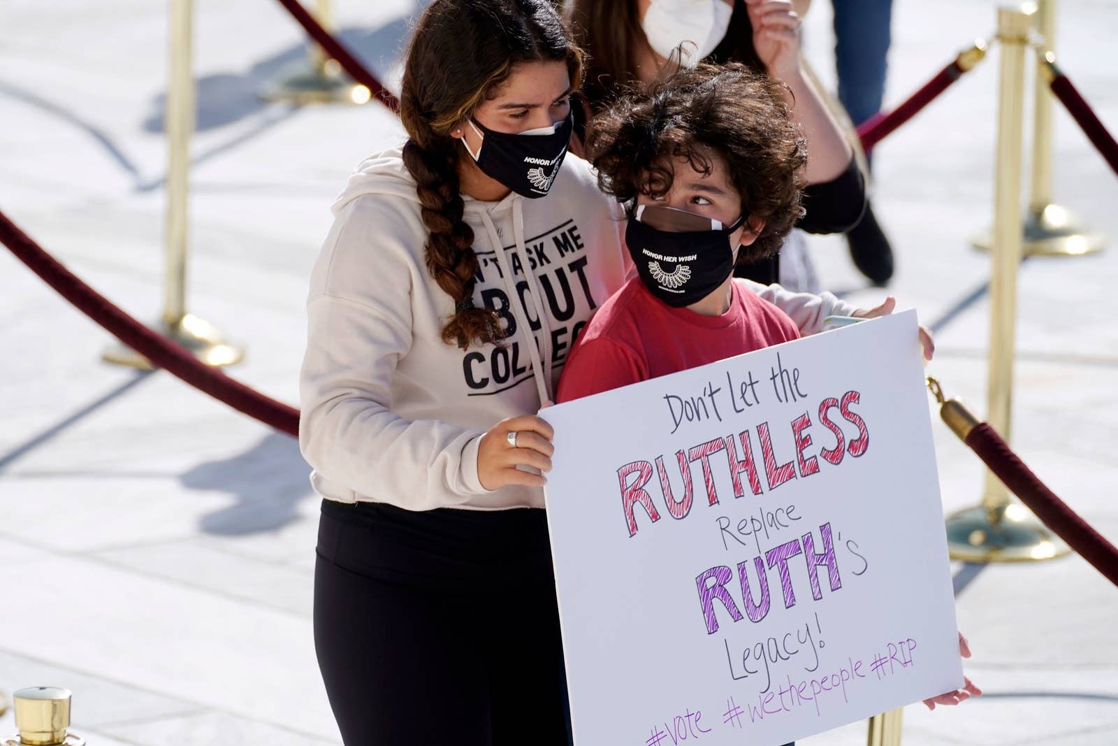 A boy carries a sign that says dont let the ruthless replace ruths legacy