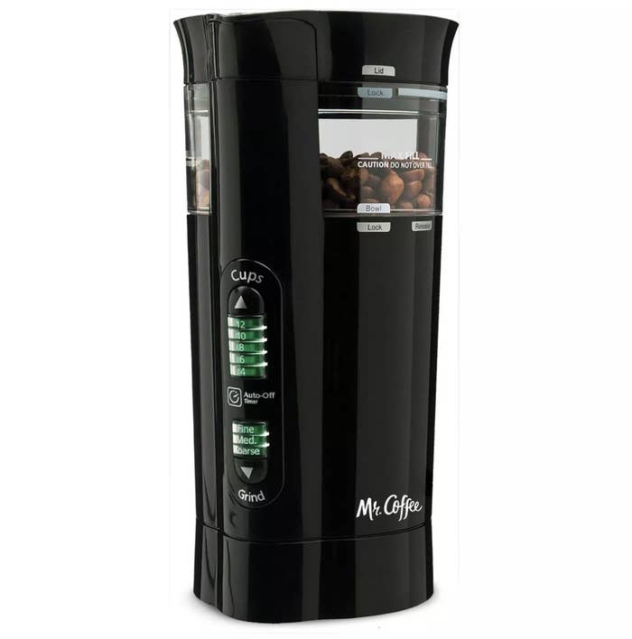 A black electric coffee grinder with coffee beans inside