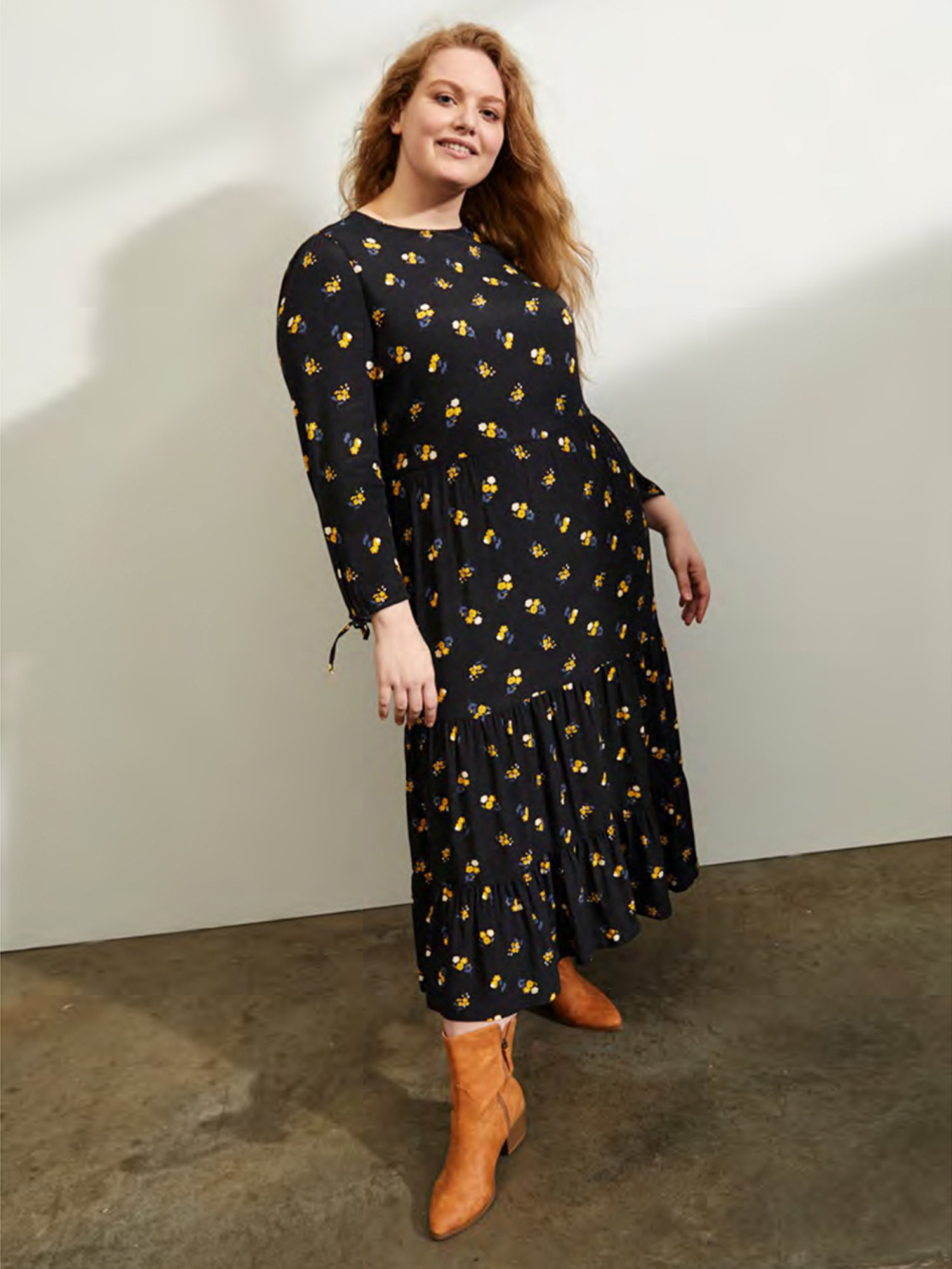 Model wears black dress with small yellow floral pattern