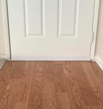 Reviewer shows white door sweep attached to white door inside their home