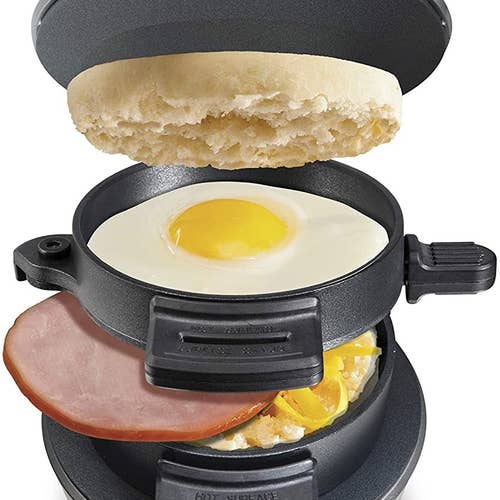 The sandwich maker filled with bread, an egg, ham, and cheese