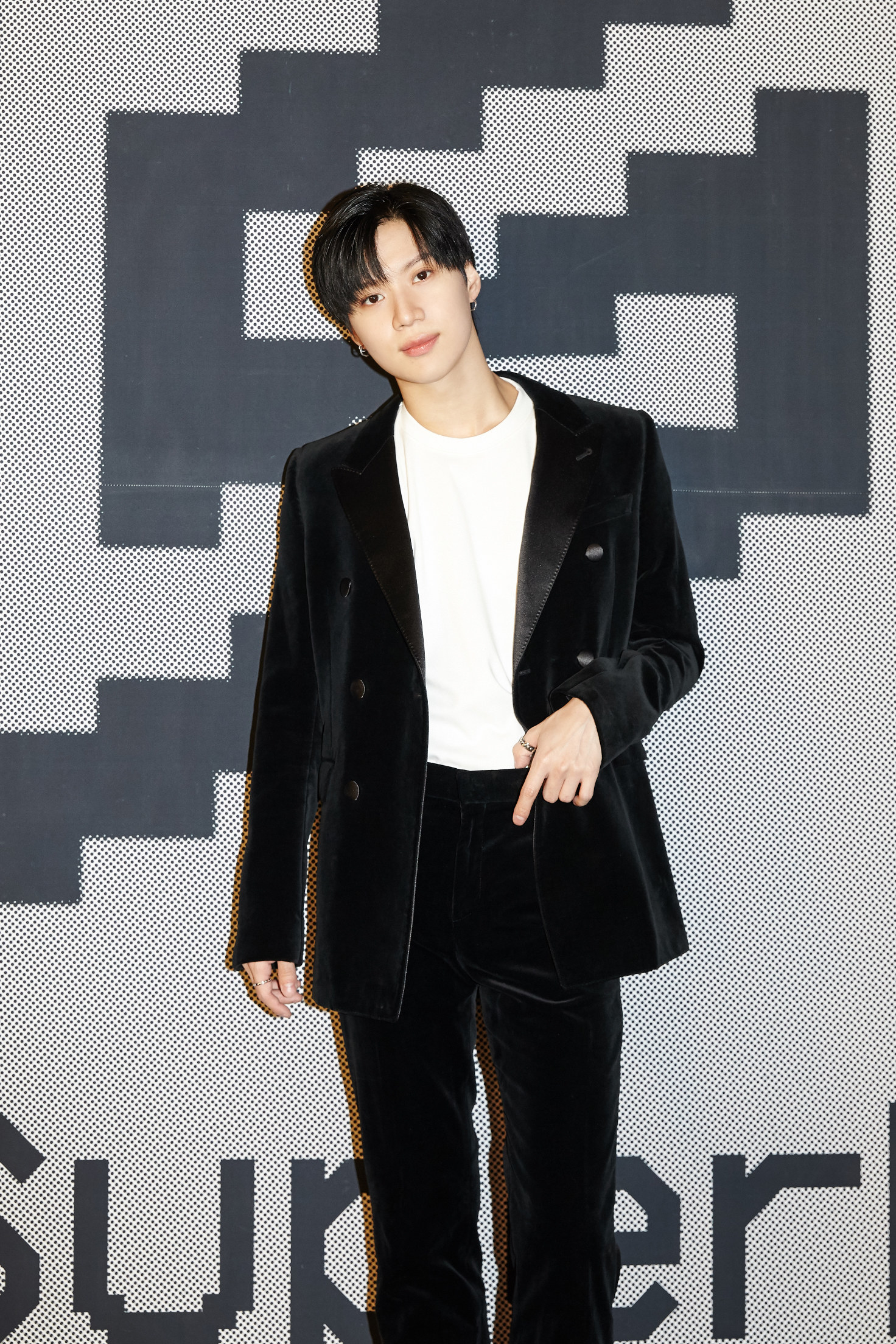 Taemin stands in a dark velvet suit 