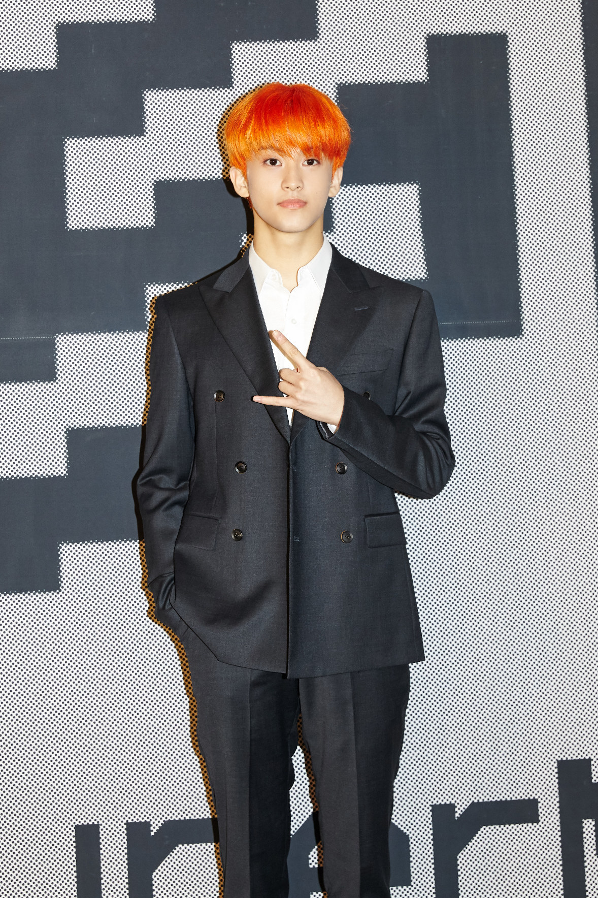 Mark Lee poses in a pressed suit