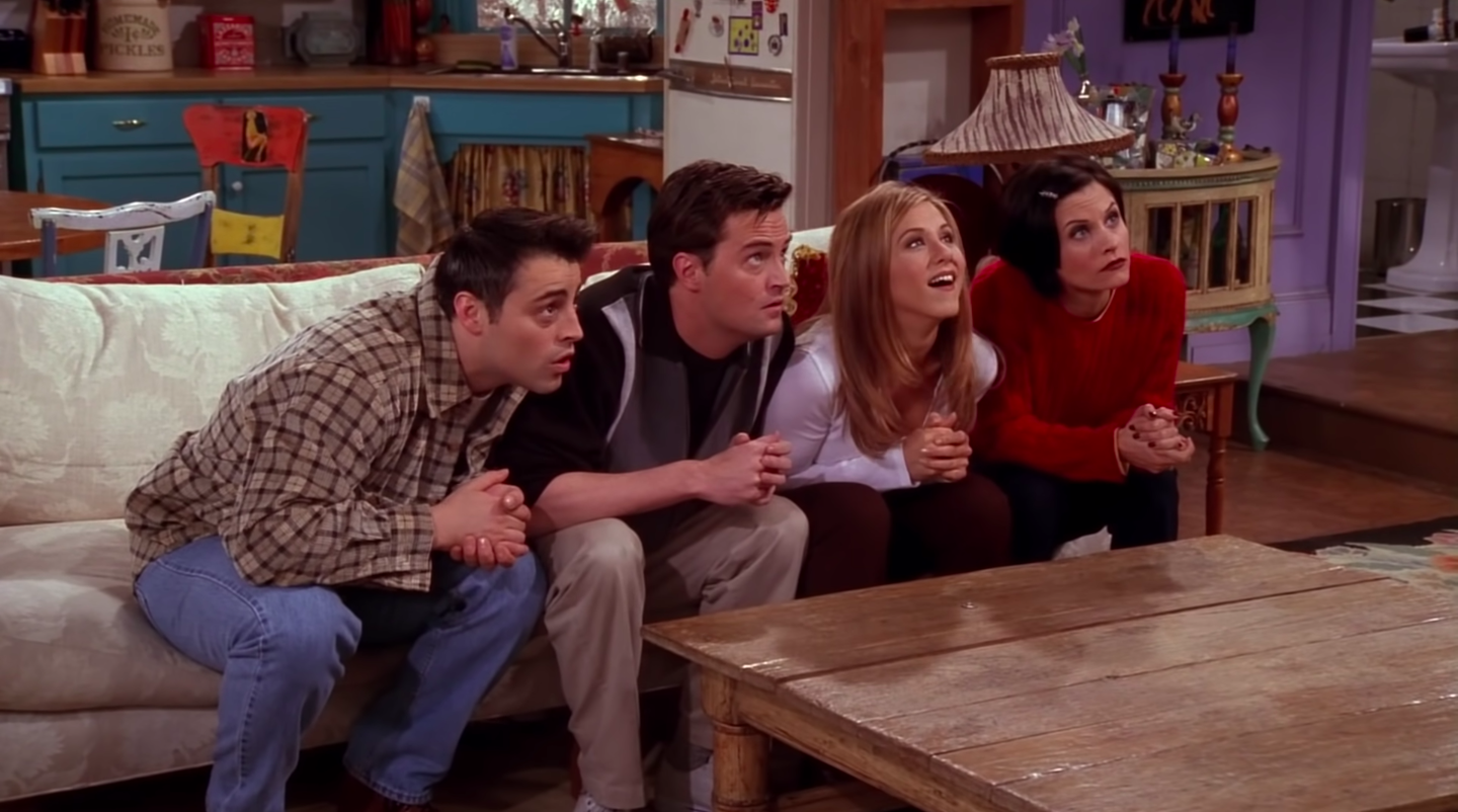 Joey, Chandler, Rachel and Monica sit on the apartment couch, all looking up