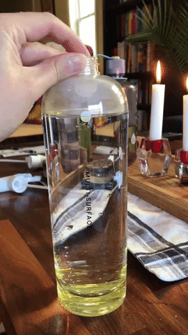 gif of the writer dropping the cleaner tablet into spray bottle of water