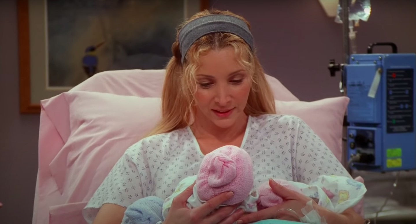 Phoebe lays in her hospital bed, holding the three newborn triplets