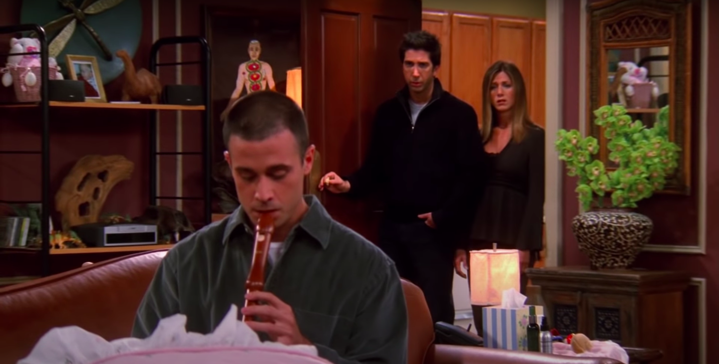 Sandy, the male nanny, plays the recorder for Emma while Rachel and Ross look on