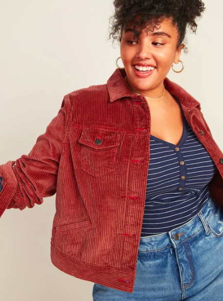 A person wears a corduroy jacket over a shirt and jeans