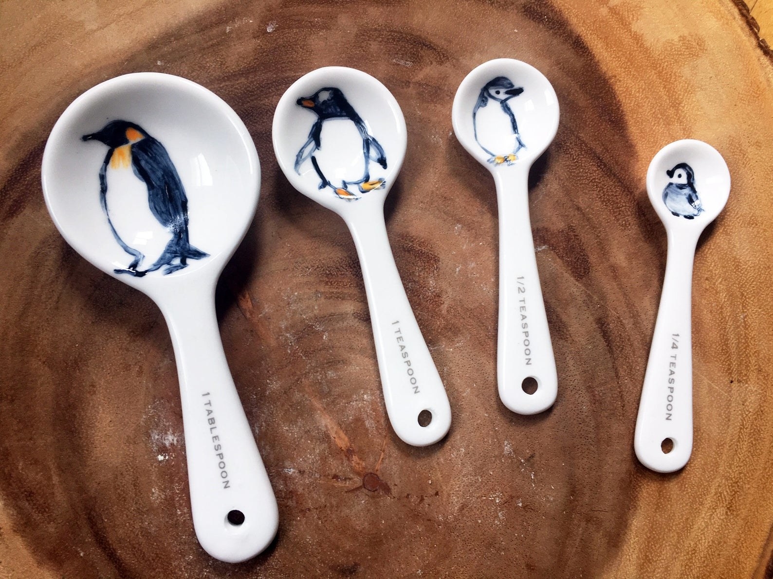 White porcelain spoons for measuring 1 tablespoon, 1 teaspoon, 1/2 teaspoon, and 1/4 teaspoon