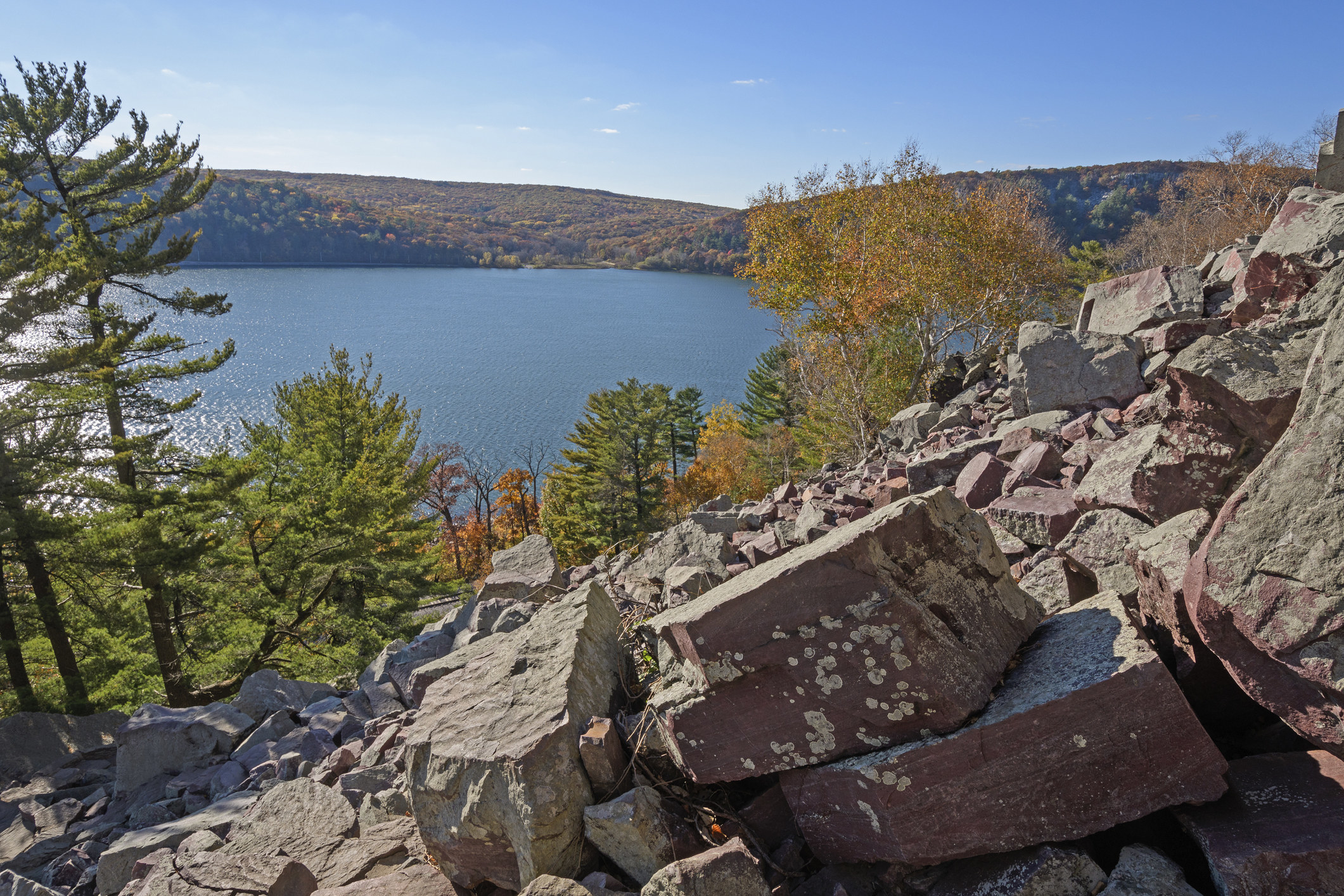Fall-colored trees surround rocks and water at Devil&#x27;s Lake State Park in Wisconsin
