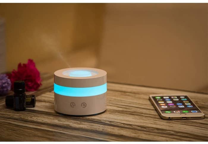 An essential oil diffuser with a blue light giving off mist