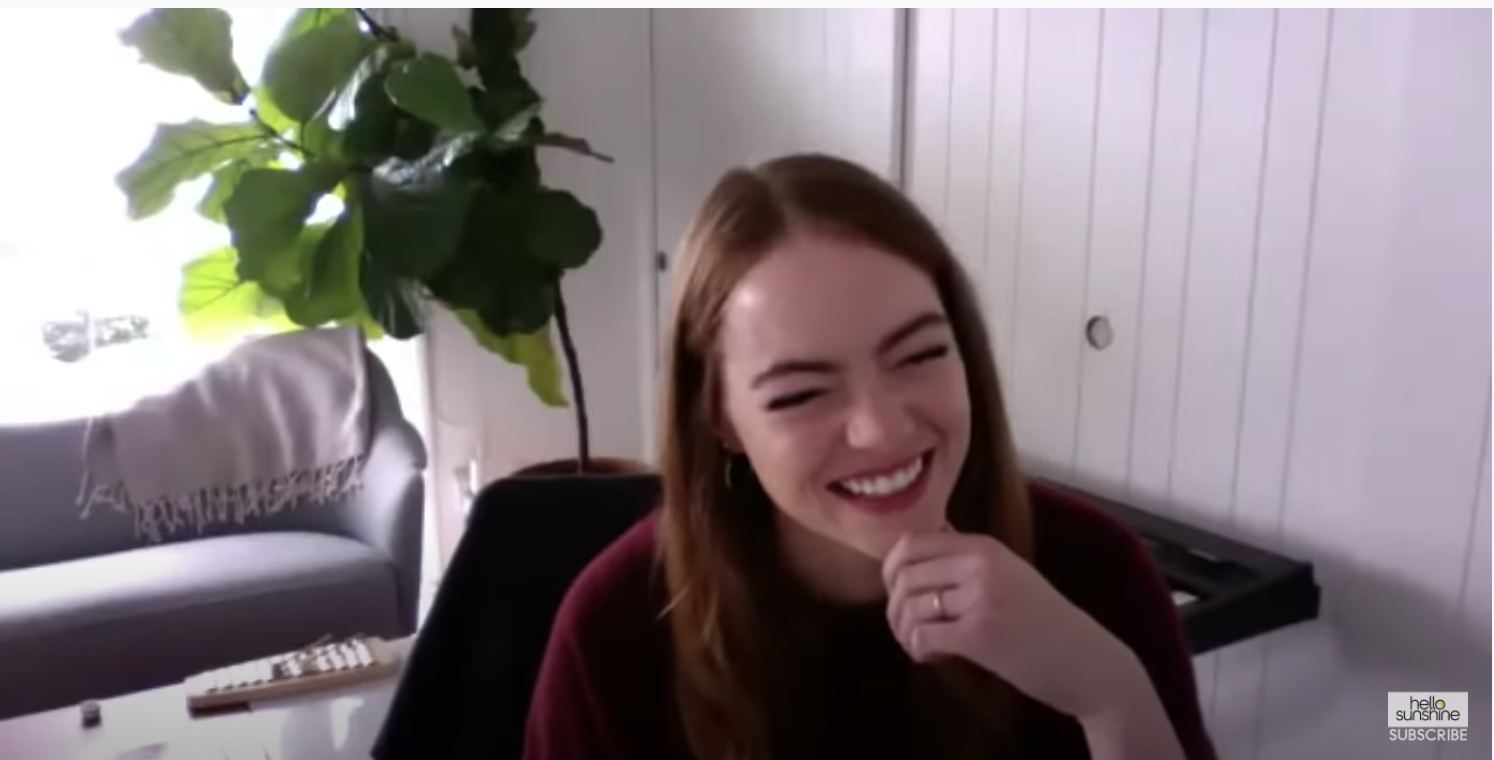 Screenshot of Emma laughing and holding her chin with a wedding band on her finger