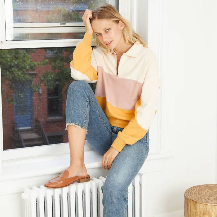 Model wearing the yellow cream sweatshirt