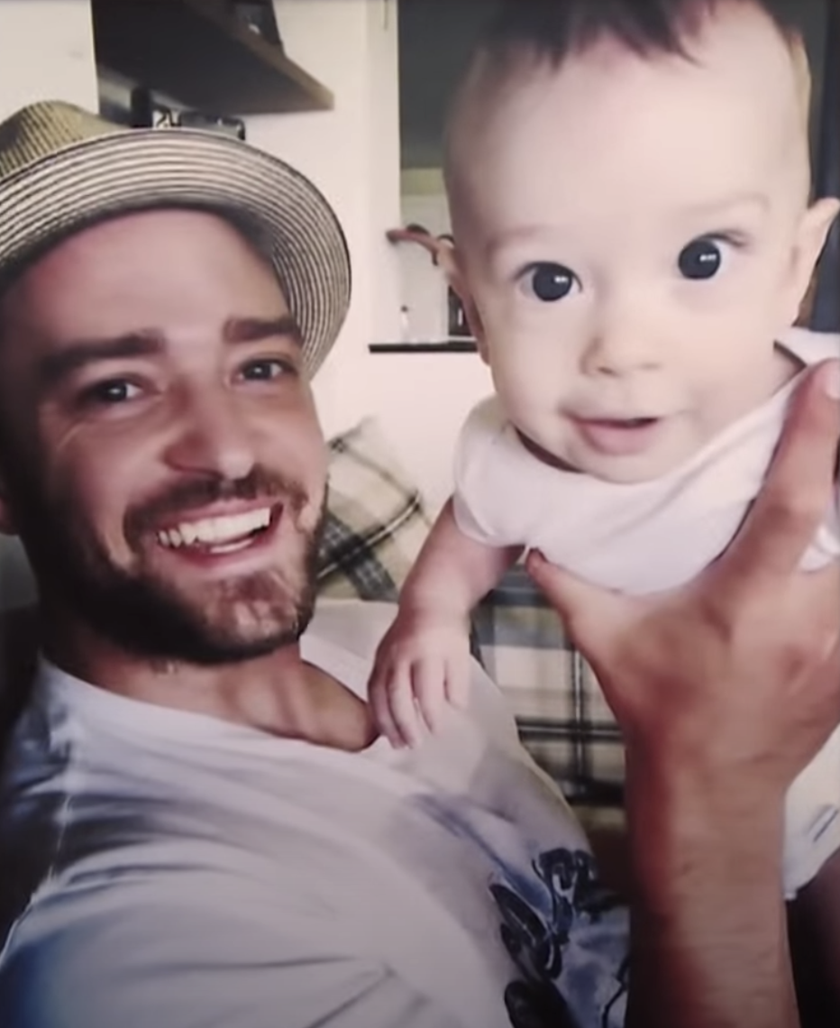 Justin Timberlake smiling and holding baby Silas