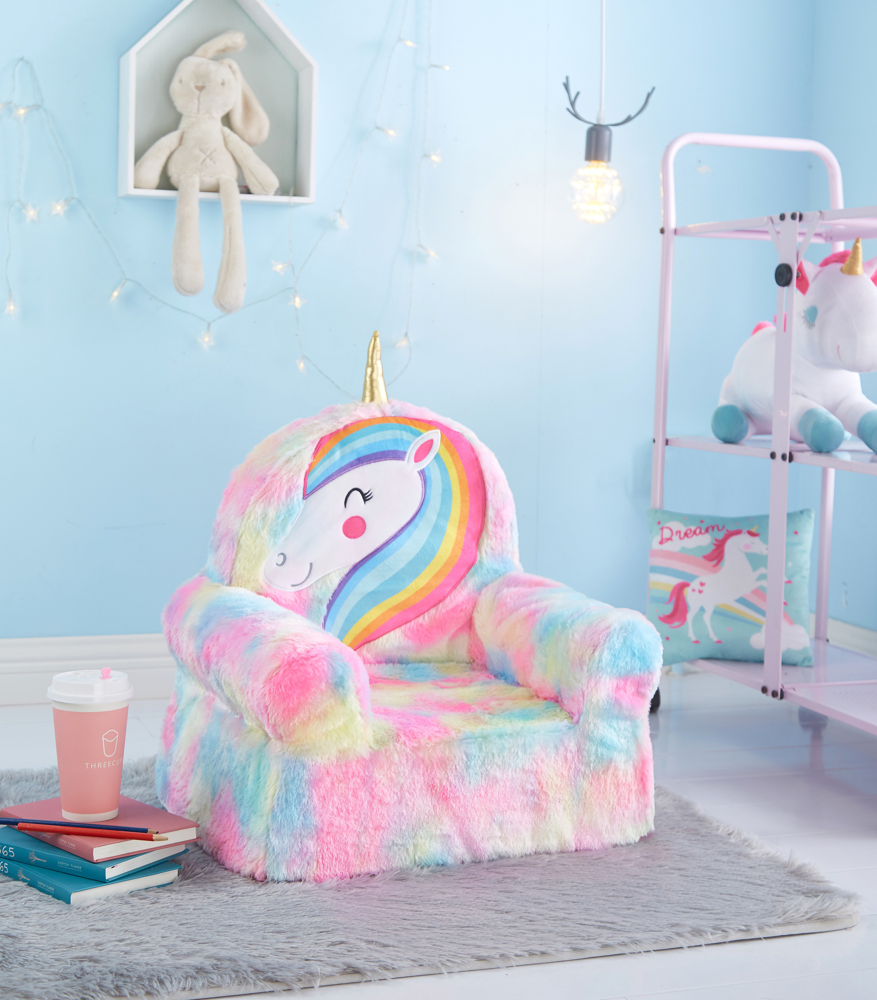 A fuzzy rainbow unicorn chair in a brightly colored room