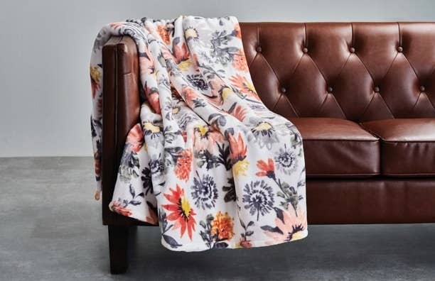 The floral blanket on couch 