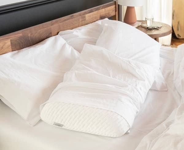 The white pillow with a white pillowcase over it