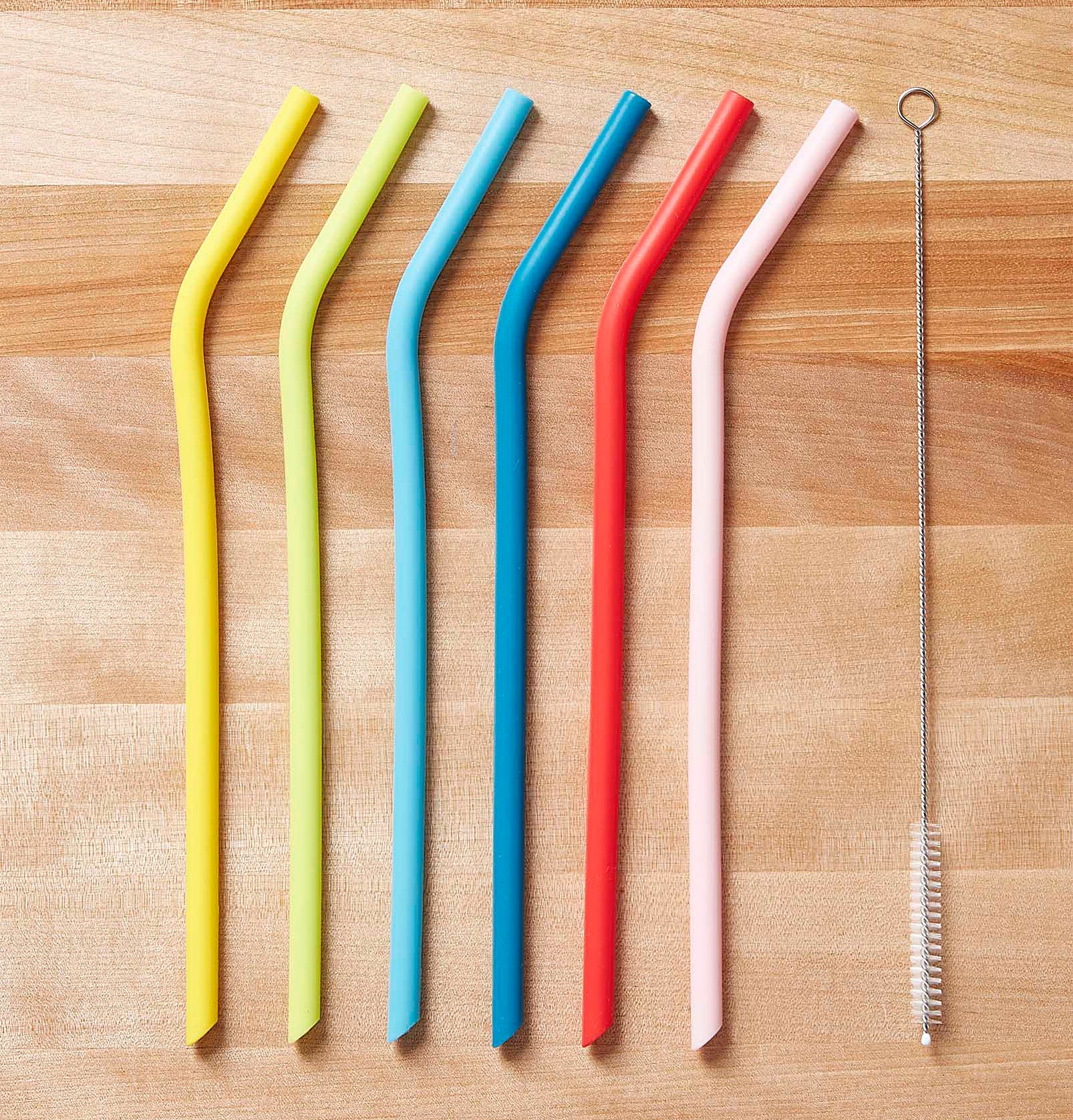 The straws and cleaning brush on a wooden table