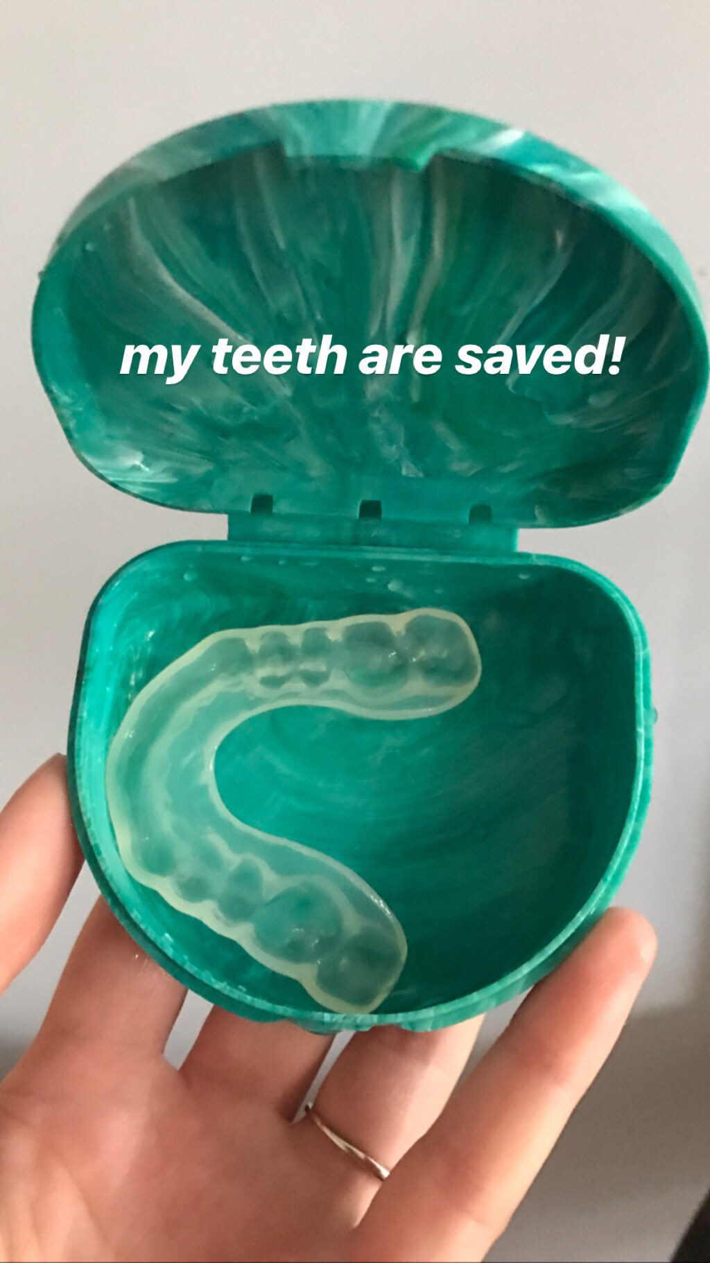 my hand holding mouth guard that says &quot;my teeth are saved&quot;