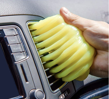 Model using yellow gel to clean an A/C unit in a car 