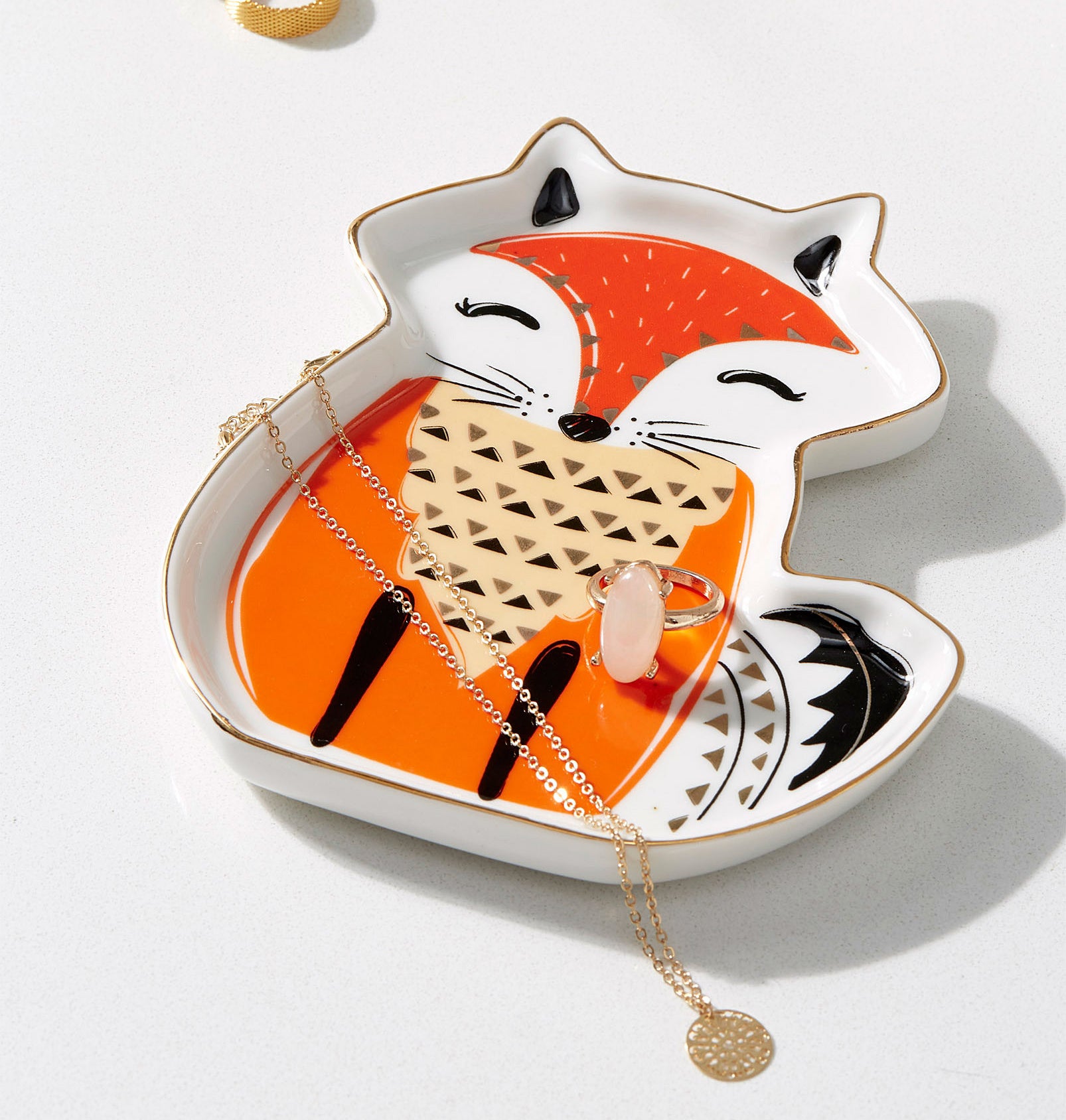 The fox dish with rings and necklaces inside of it