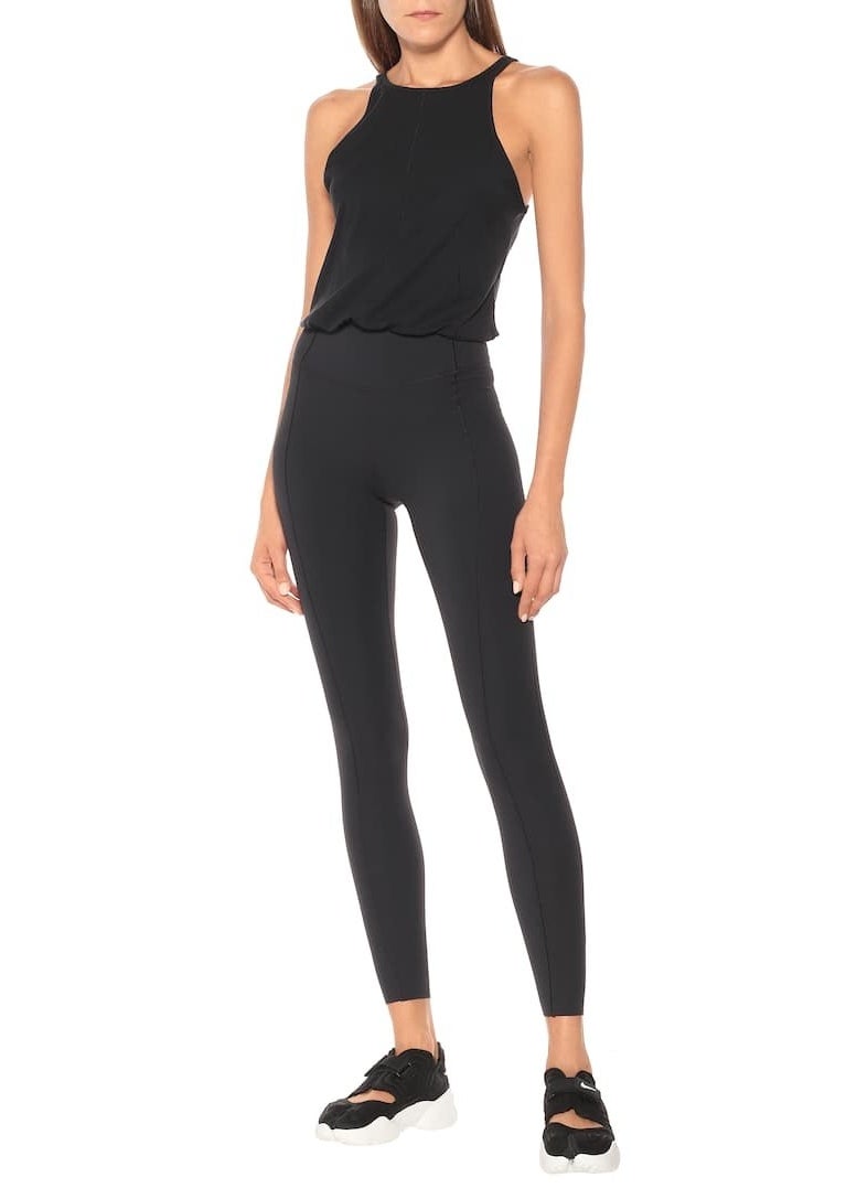model wearing black bodysuit with tight leggings and looser top