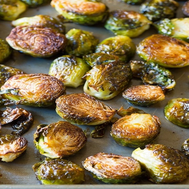 Roasted halved Brussels sprouts on a sheet pan.