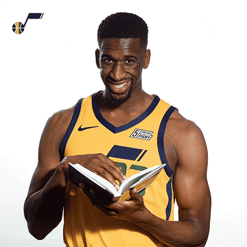 Basketball player smiling and turning pages in a book