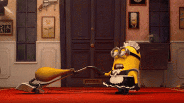 A minion in a maid outfit vacuuming 