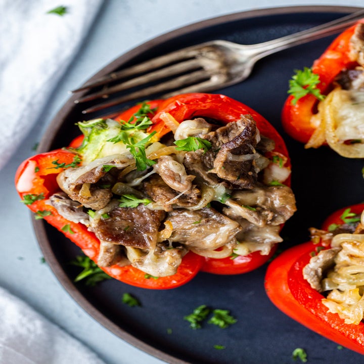 Three bell peppers stuffed with thinly sliced beef, melted cheese, and herbs.