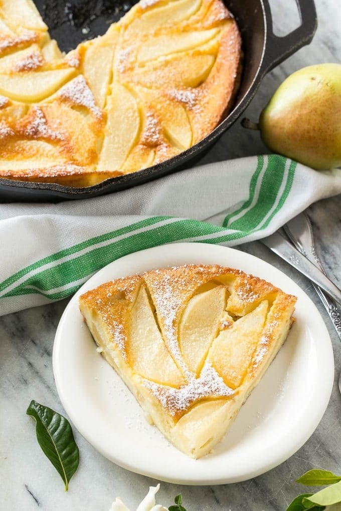 A slice of pear custard pie with powdered sugar on top.