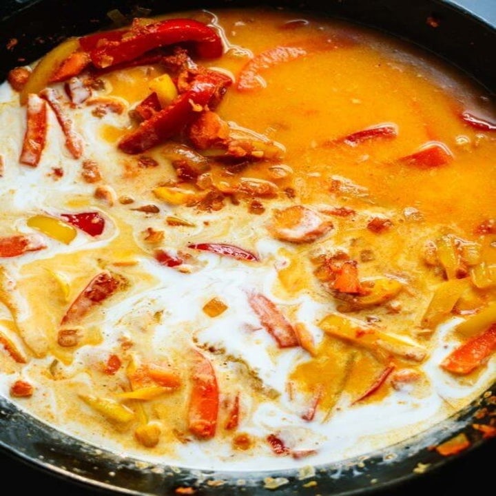 Red curry sauce in a pot with vegetables.