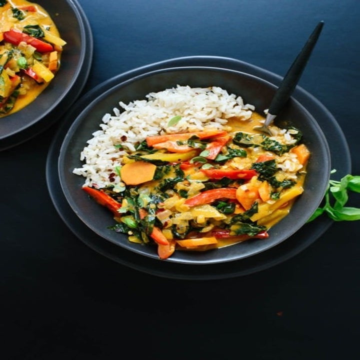 A bowl of red vegetable curry with rice.