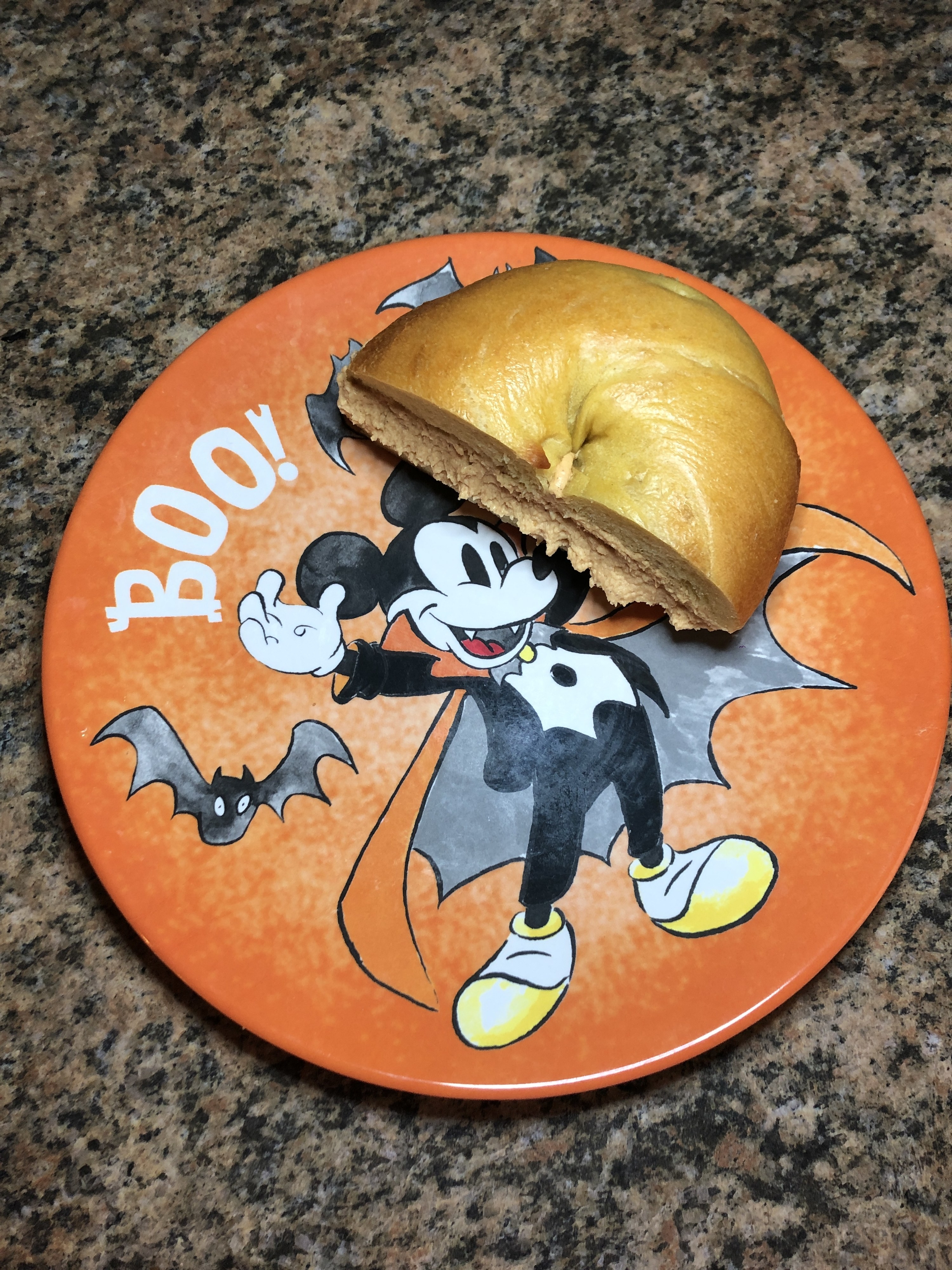 buzzfeed editor&#x27;s orange plate with vampire mickey on it and a bagel