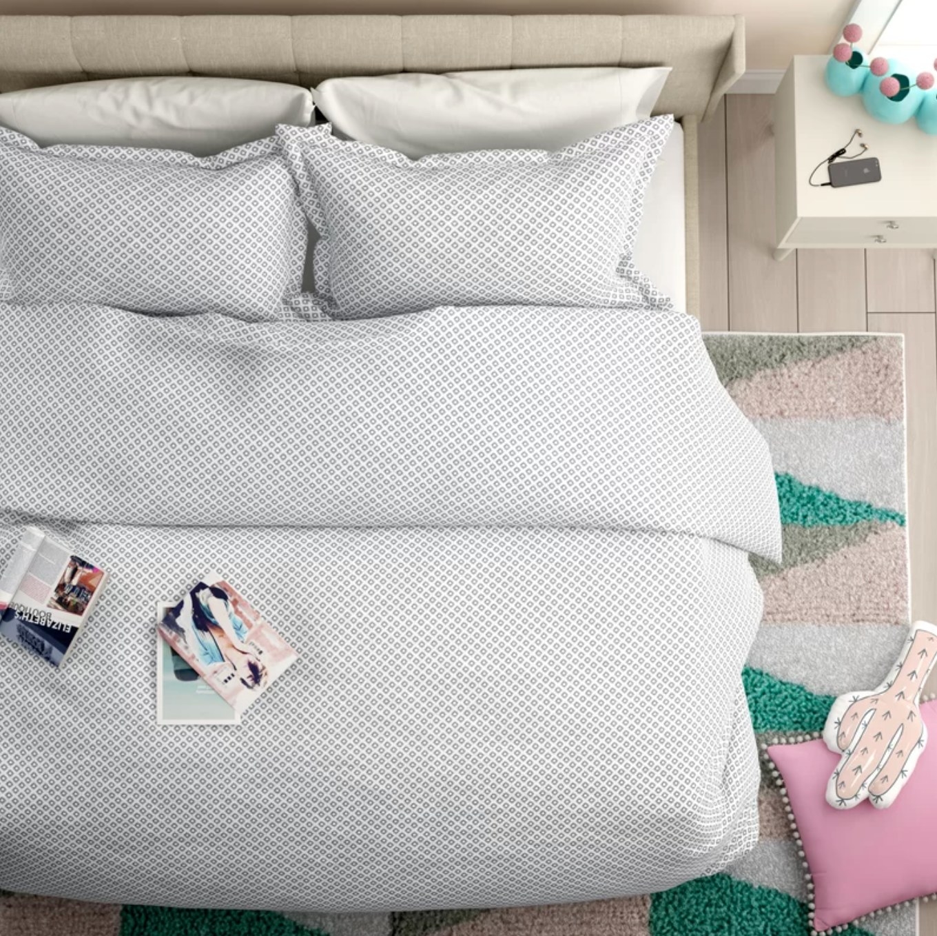 The duvet cover on a bed, sitting atop a colorful rug