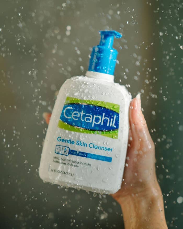 Model holding Cetaphil cleanser in the shower