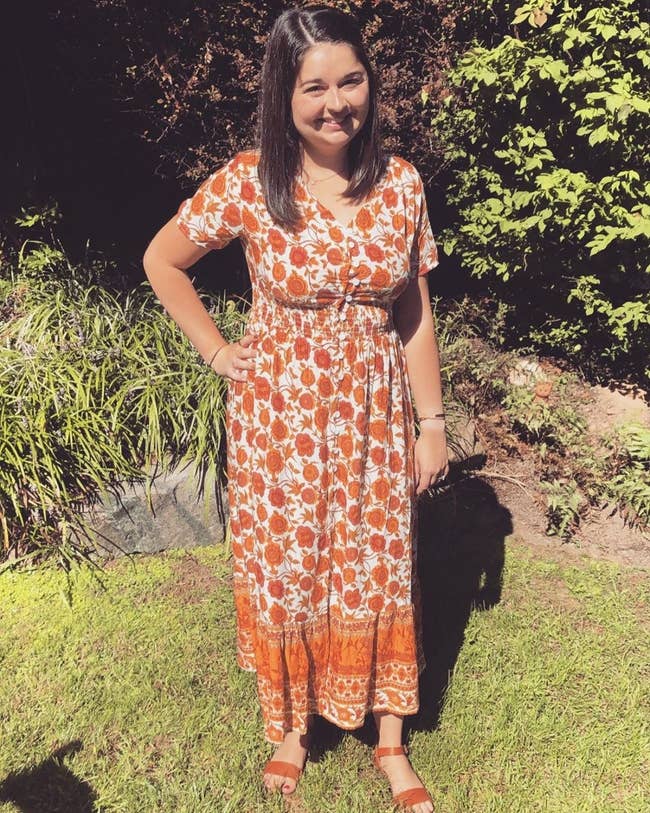buzzfeed editor wearing a button-up orange midi dress with a floral pattern 
