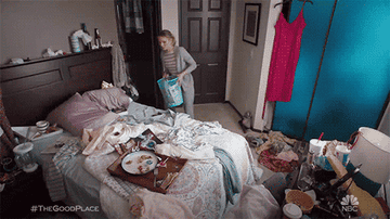 Eleanor Shellstrop from &quot;The Good Place&quot; cleaning up a messy bedroom and throwing trash out