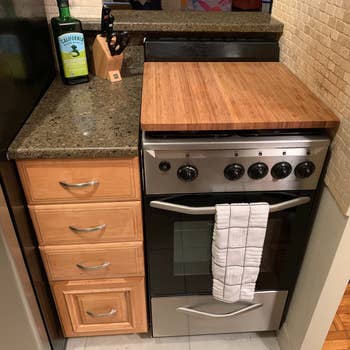 a kitchen stove with the bamboo burner cover on top creating more counter space 