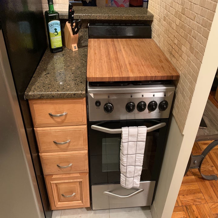 a kitchen stove with the bamboo burner cover on top creating more counter space 