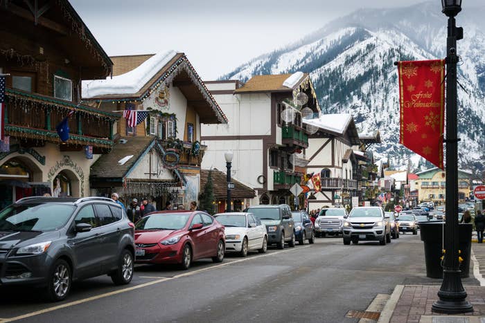 Busy street lined with European-style buildings and a snowy mountain in the background