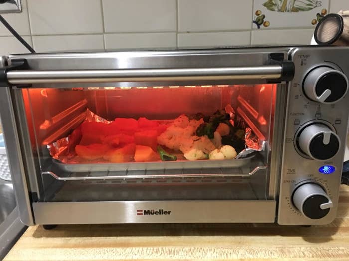A reviewer image of some vegetables cooking inside the toaster oven
